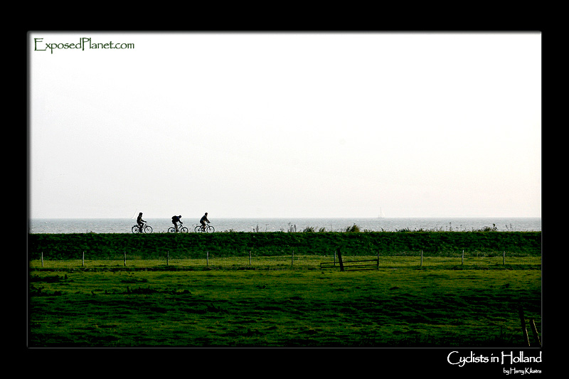Dutch Cyclists fighting the wind on a dike
