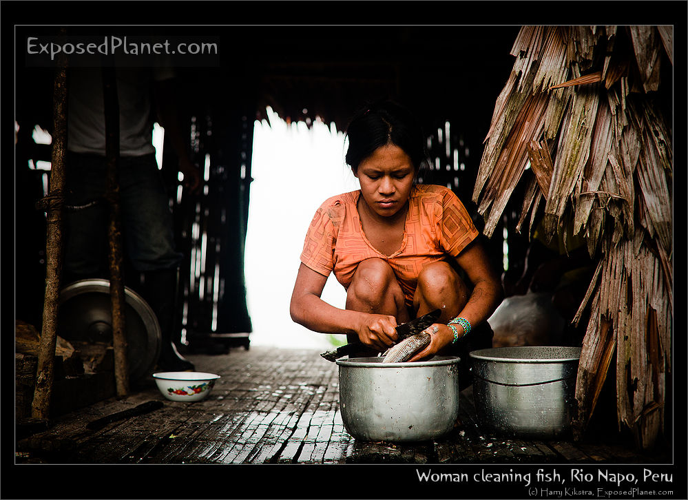 Young woman cleaning fish, Rio Napo, Peru