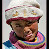 Child in Tibet with Buddhist deer hat